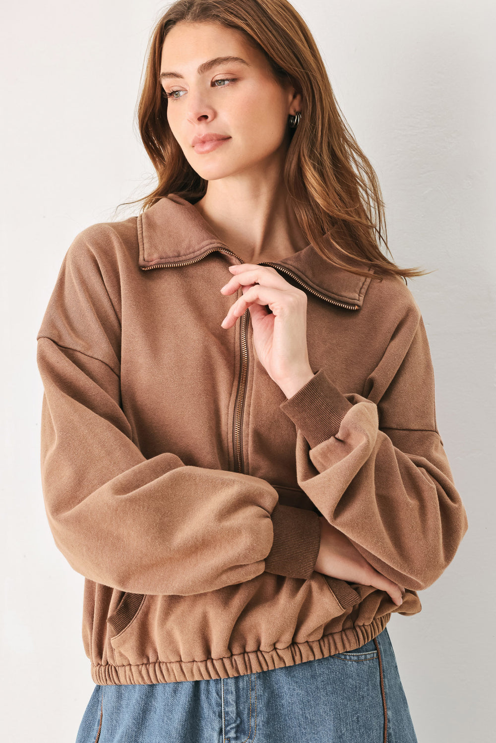 A woman wearing a brown half-zip pullover sweatshirt with a collar and front pockets, paired with light blue jeans | FREEMARKET