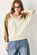 A woman wearing a color-blocked long-sleeve V-neck sweatshirt with cream and tan panels | FREEMARKET