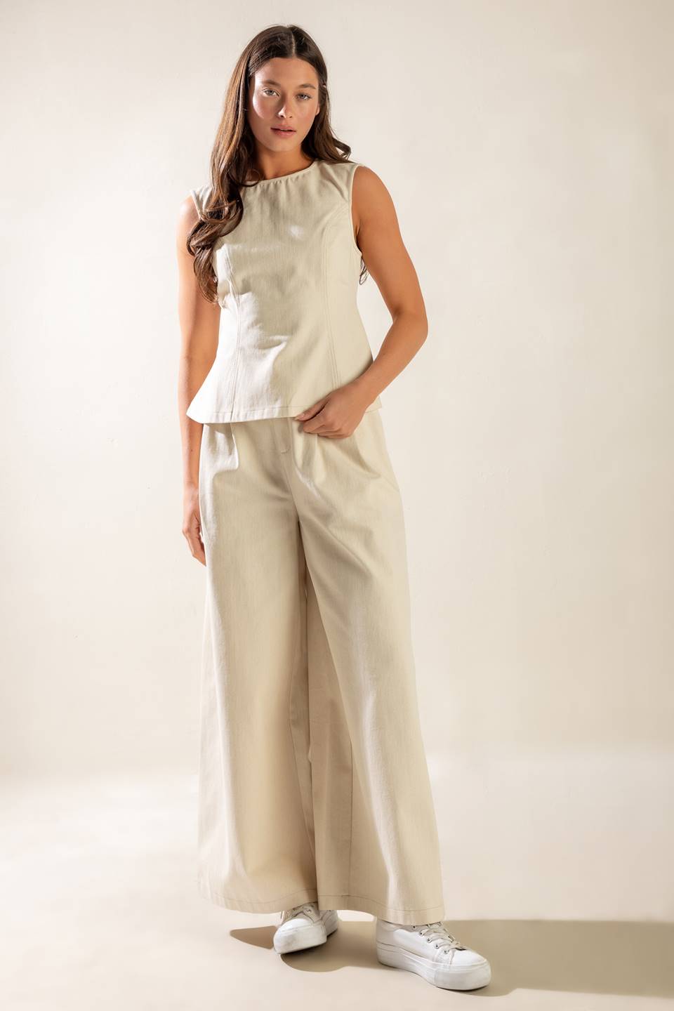 A solid twill top featuring round neckline, sleeveless, back cut out and button/tie closure.