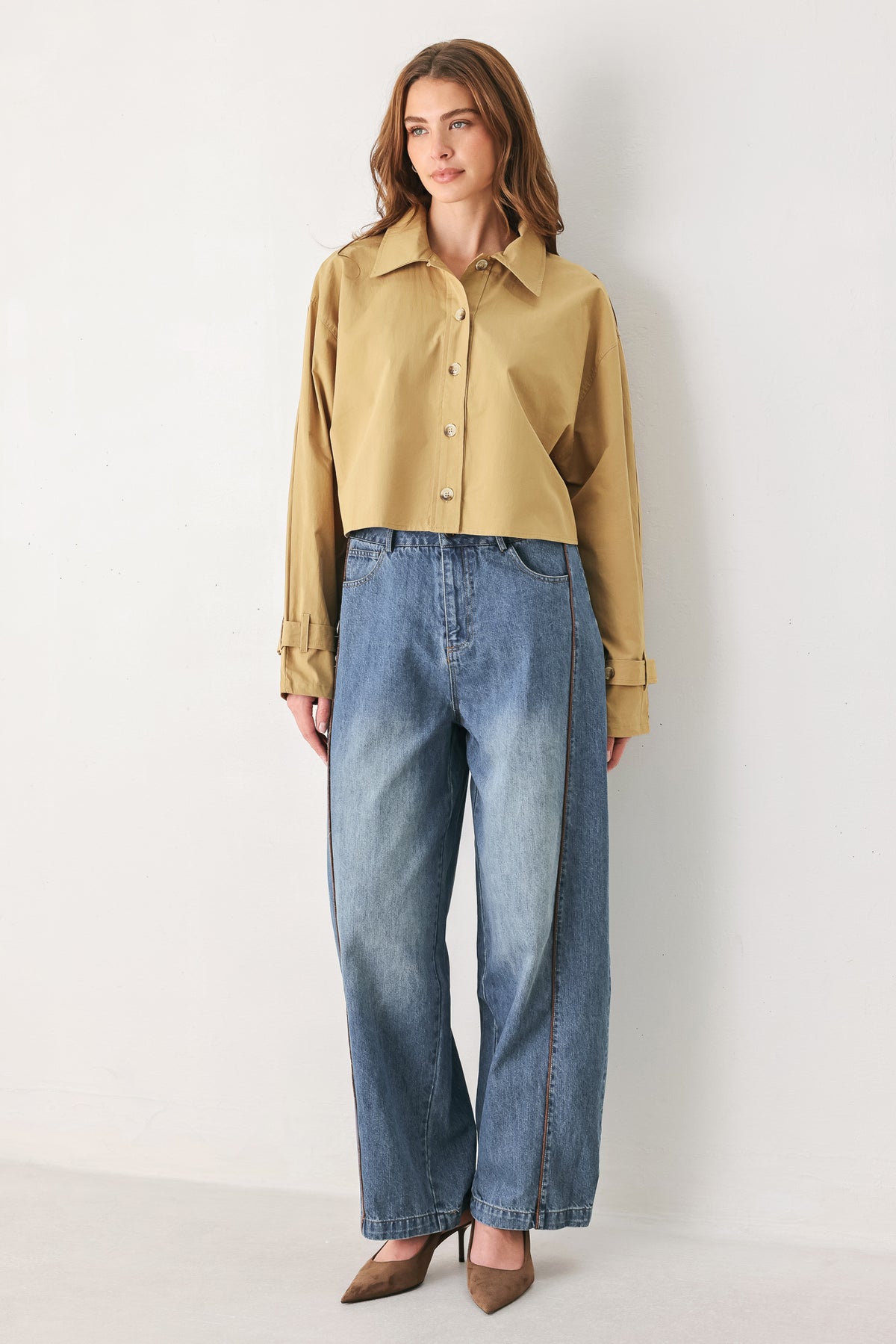 A woman wearing a camel tan button-up shirt with a pointed collar and brown-tone buttons | FREEMARKET