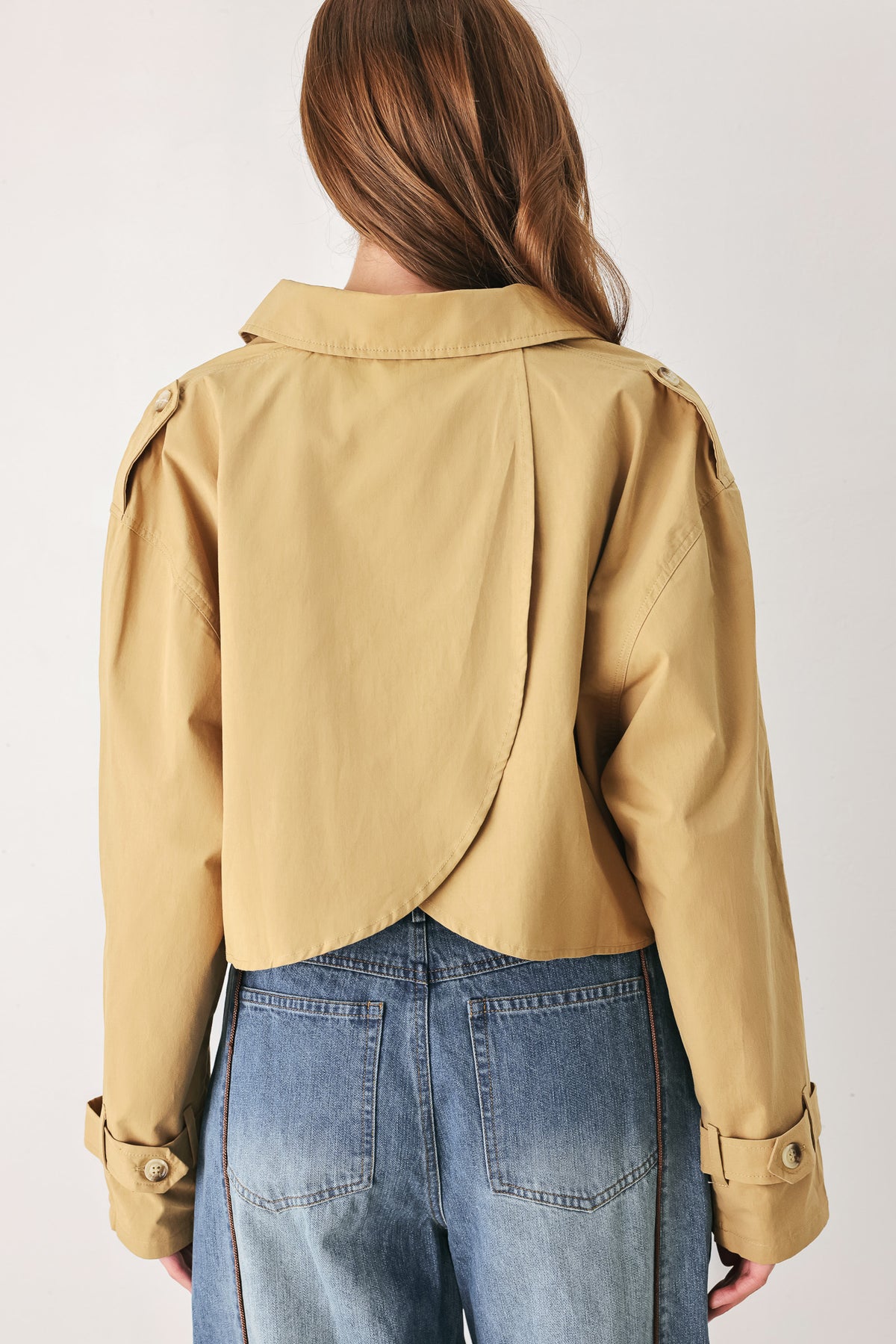 A woman wearing a camel tan button-up shirt with a pointed collar and brown-tone buttons | FREEMARKET