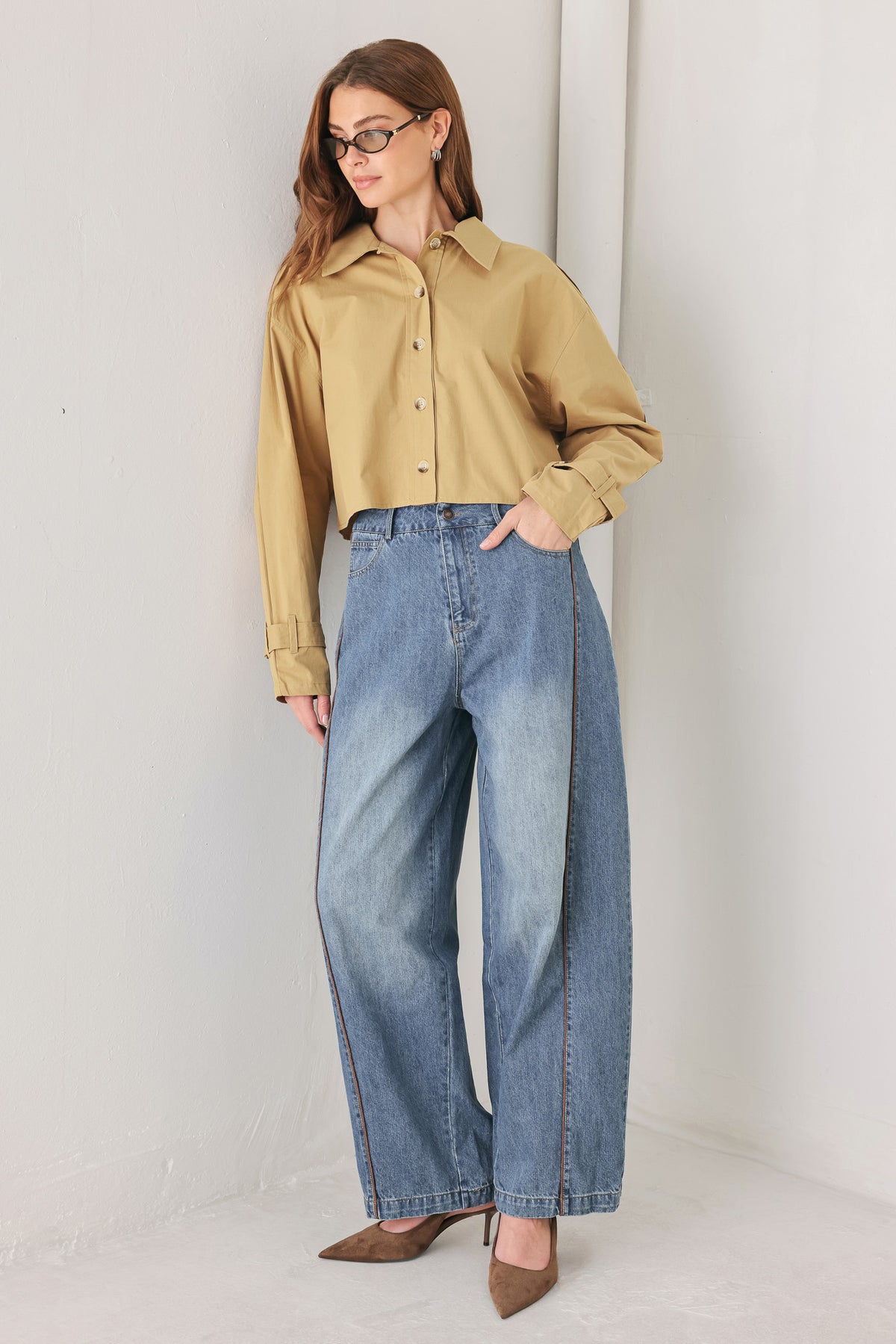 A woman wearing a camel tan button-up shirt with a pointed collar and brown-tone buttons | FREEMARKET
