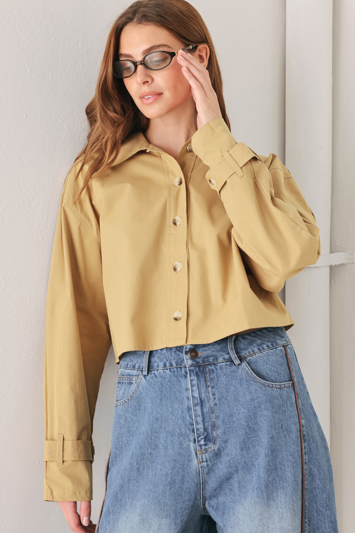 A woman wearing a camel tan button-up shirt with a pointed collar and brown-tone buttons | FREEMARKET