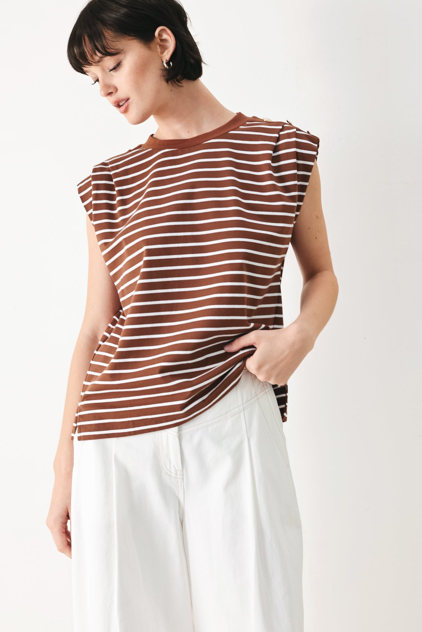 Woman wearing a brown and white striped knit top with crew neckline, sleeveless and should button detail | FREEMARKET