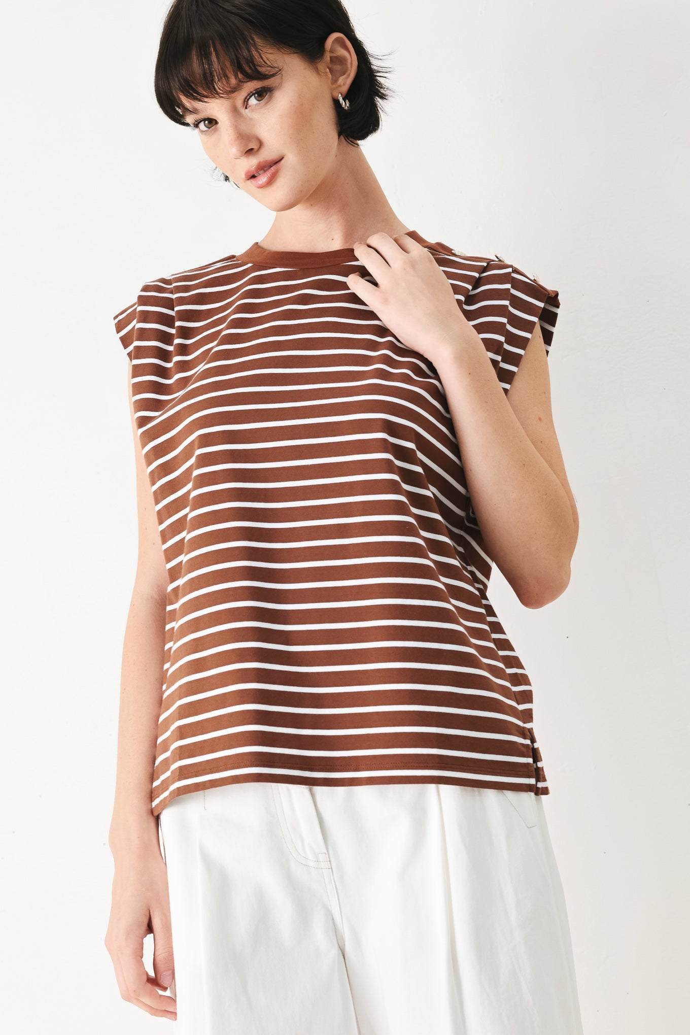 Woman wearing a brown and white striped knit top with crew neckline, sleeveless and should button detail | FREEMARKET