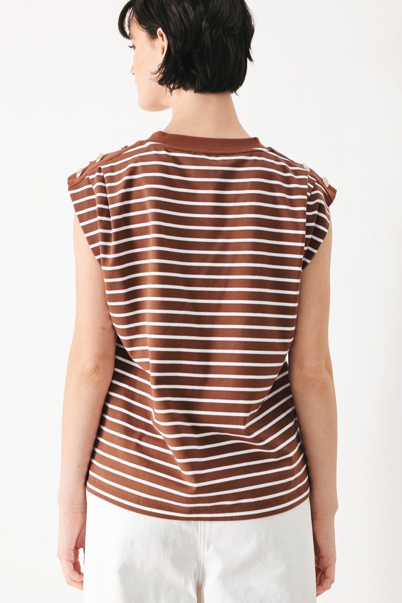 Woman wearing a brown and white striped knit top with crew neckline, sleeveless and should button detail | FREEMARKET