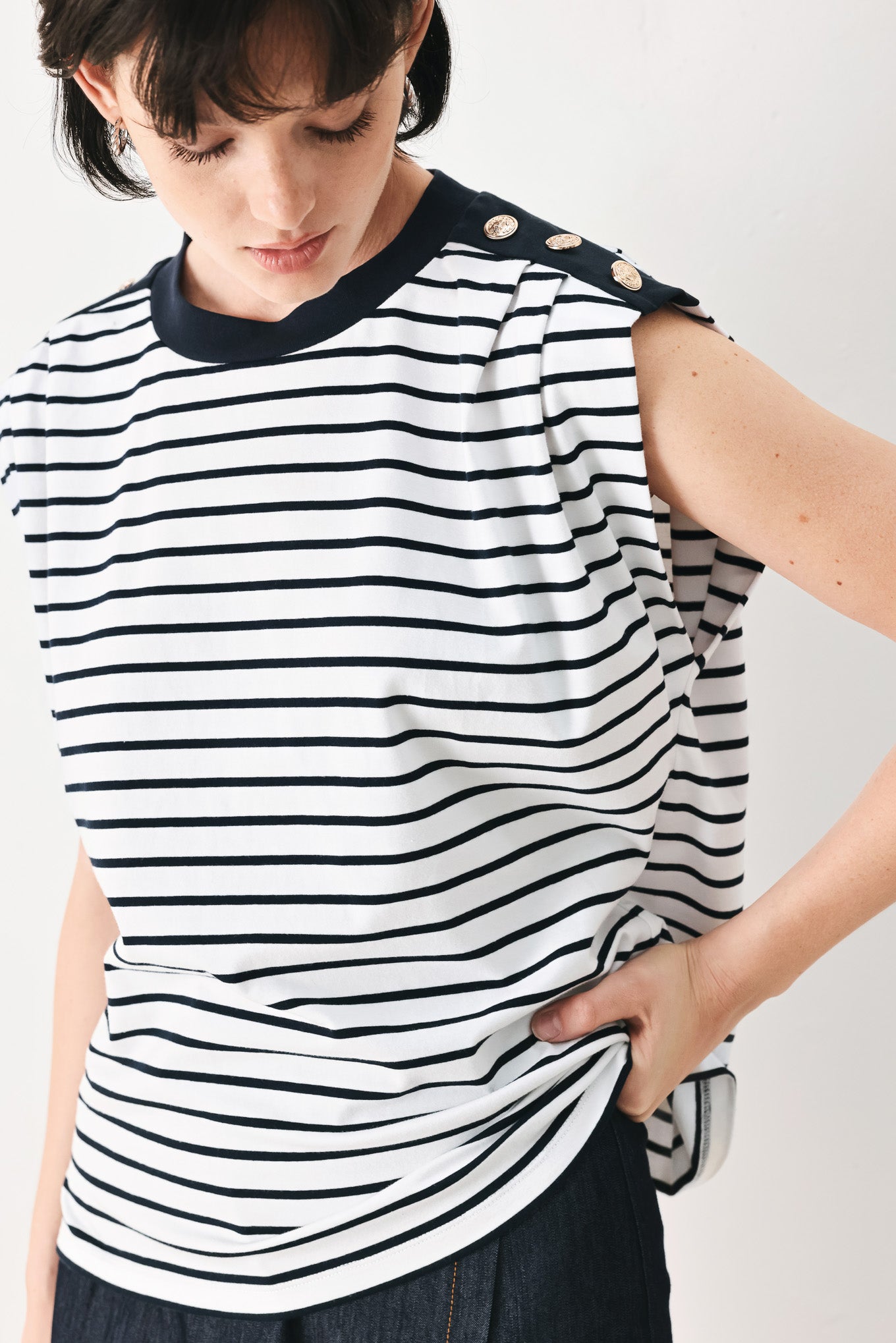 Woman wearing a navy and white striped knit top with crew neckline, sleeveless and should button detail | FREEMARKET