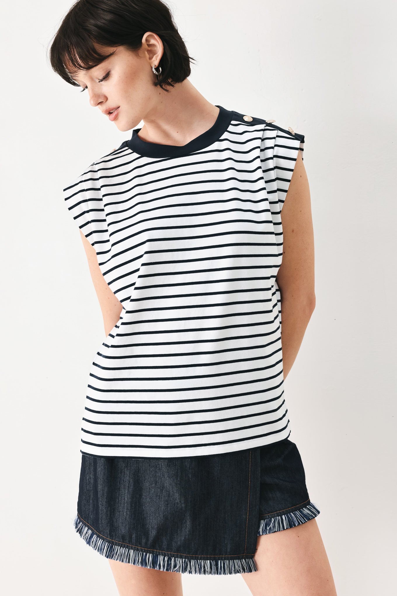 Woman wearing a navy and white striped knit top with crew neckline, sleeveless and should button detail | FREEMARKET