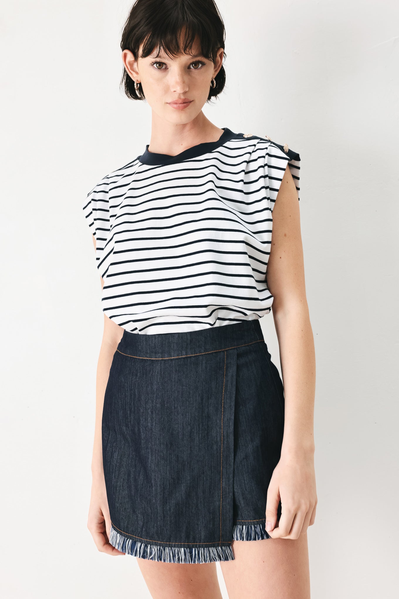 Woman wearing a navy and white striped knit top with crew neckline, sleeveless and should button detail | FREEMARKET