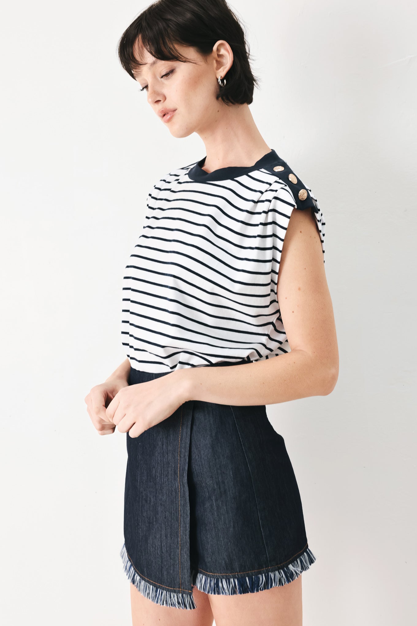 Woman wearing a navy and white striped knit top with crew neckline, sleeveless and should button detail | FREEMARKET