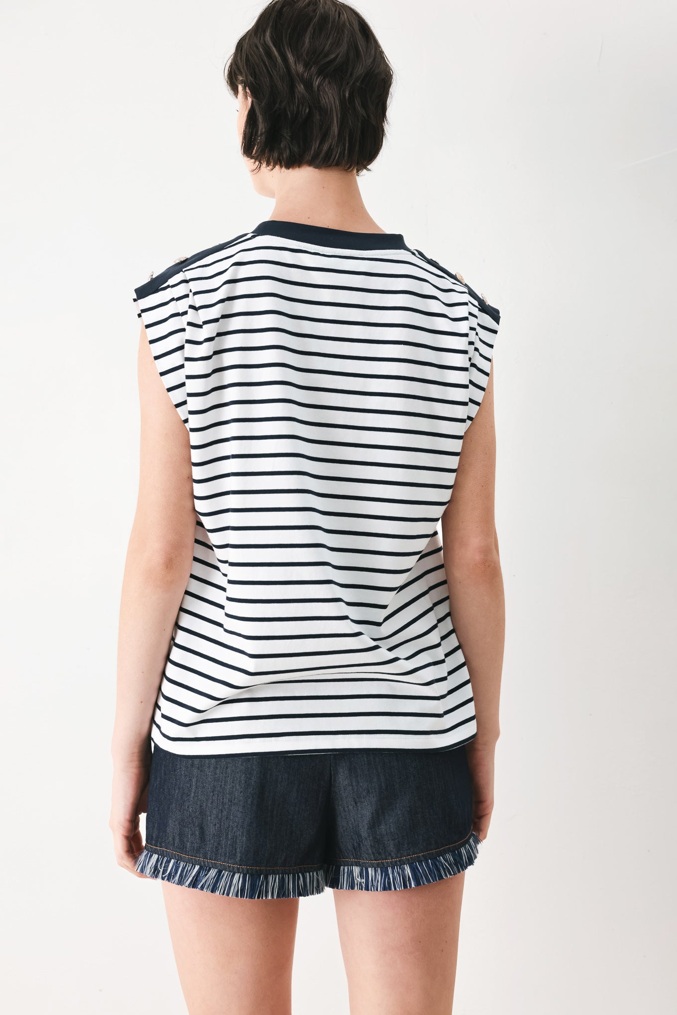 Woman wearing a navy and white striped knit top with crew neckline, sleeveless and should button detail | FREEMARKET