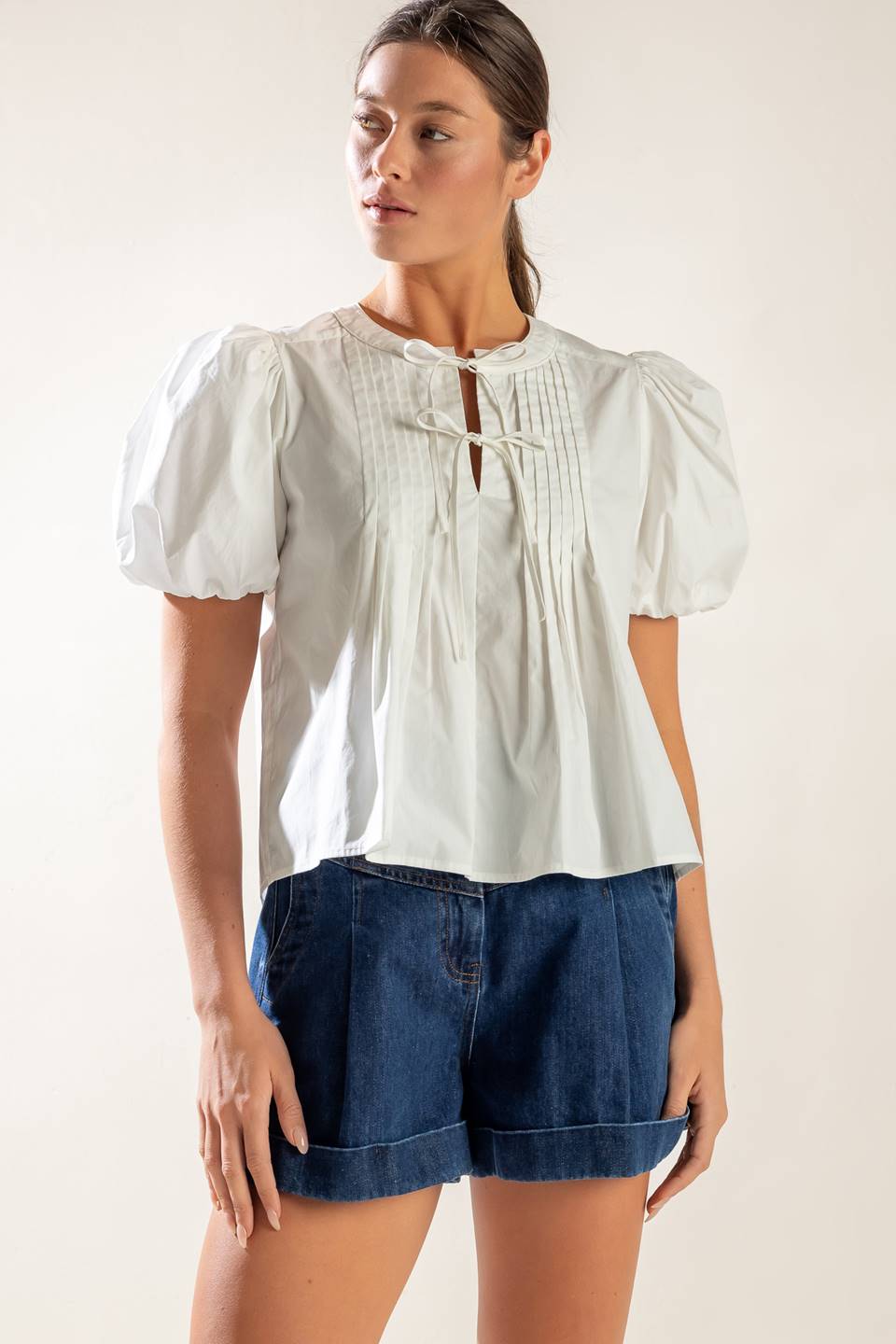 A solid white woven top featuring collar, button down and short puff sleeve.