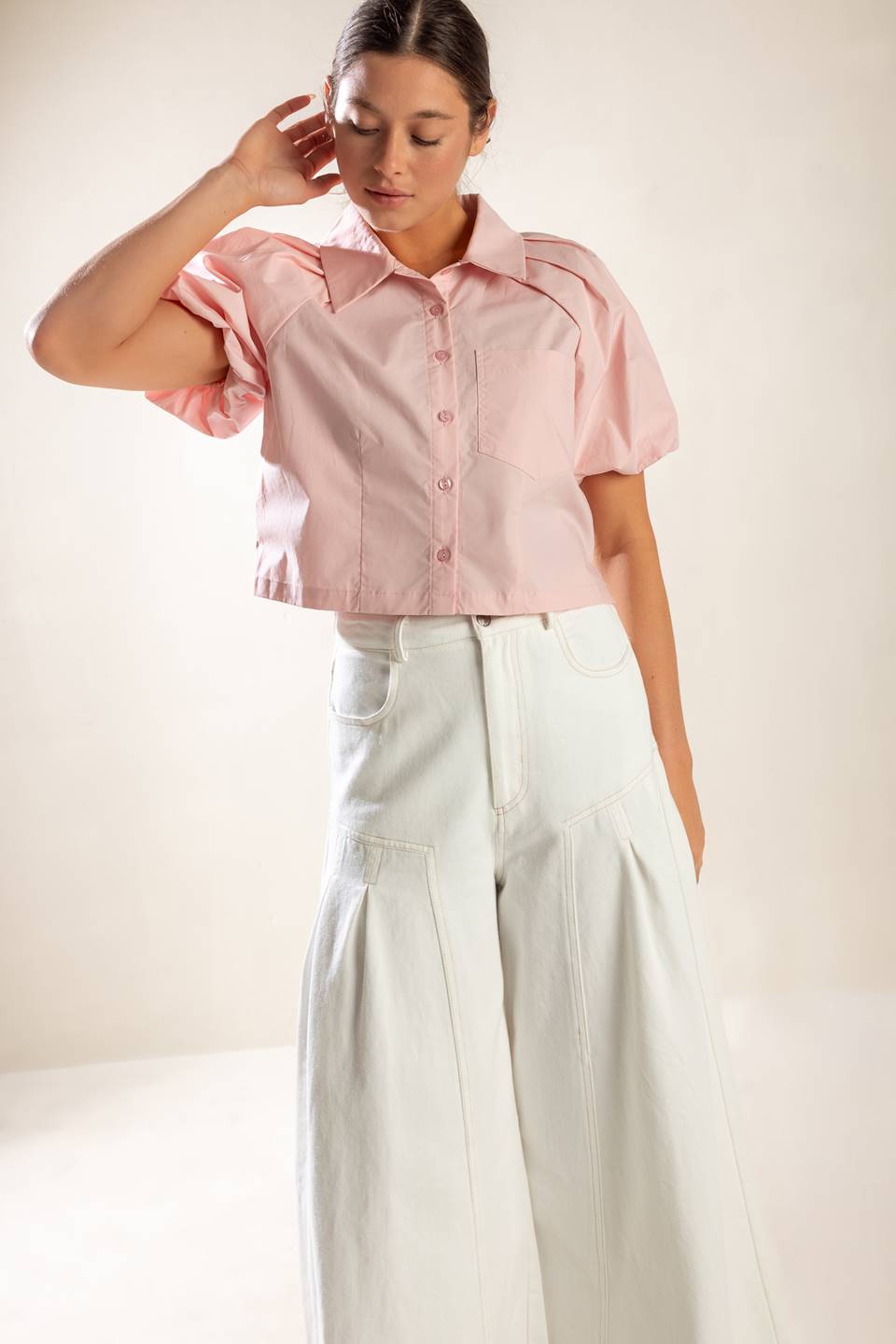 A solid baby pink woven top featuring collar, button down and short puff sleeve.