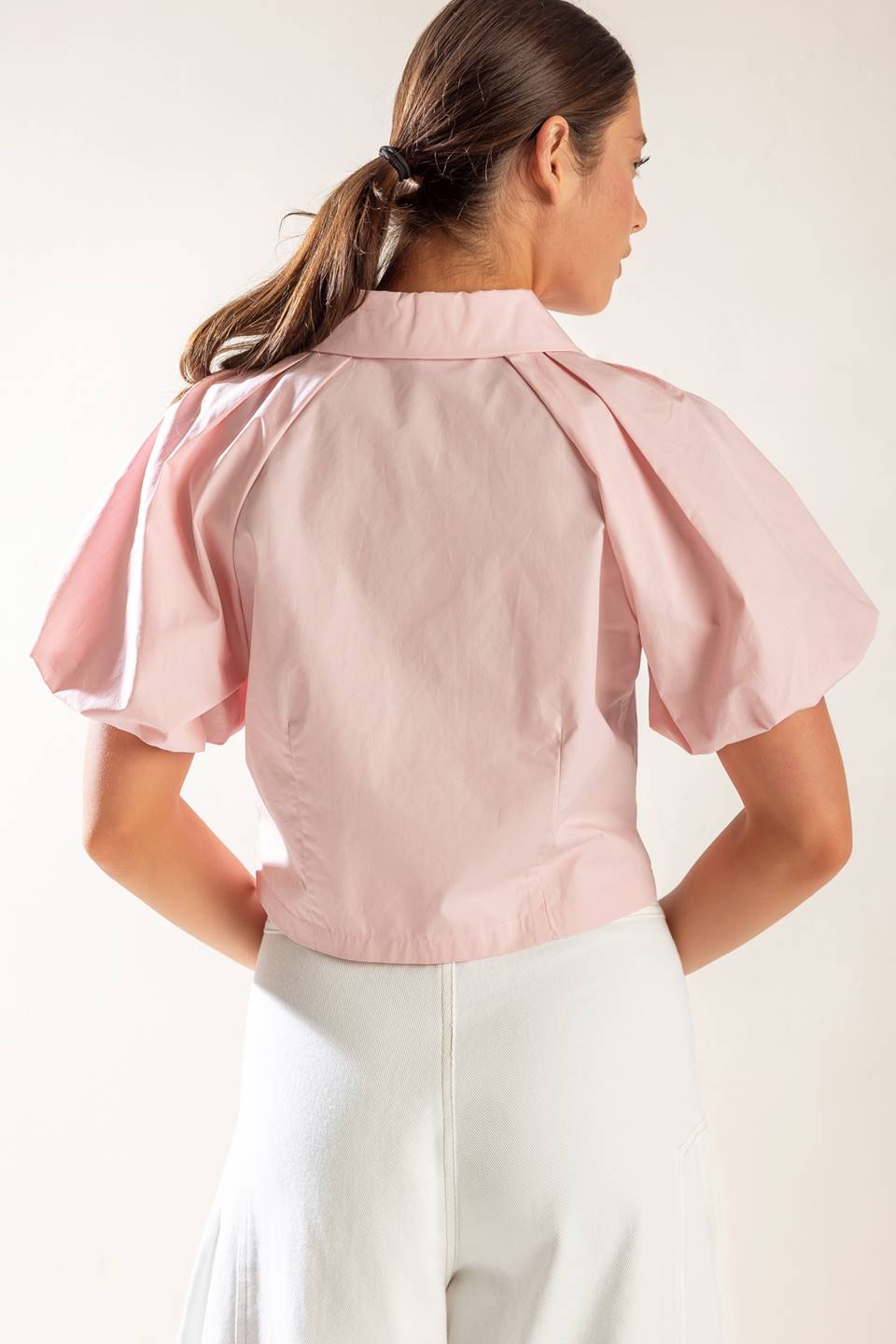 A solid baby pink woven top featuring collar, button down and short puff sleeve.