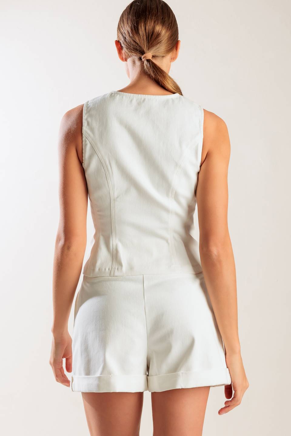 A sleeveless, solid white woven vest featuring a round neckline and front button down.