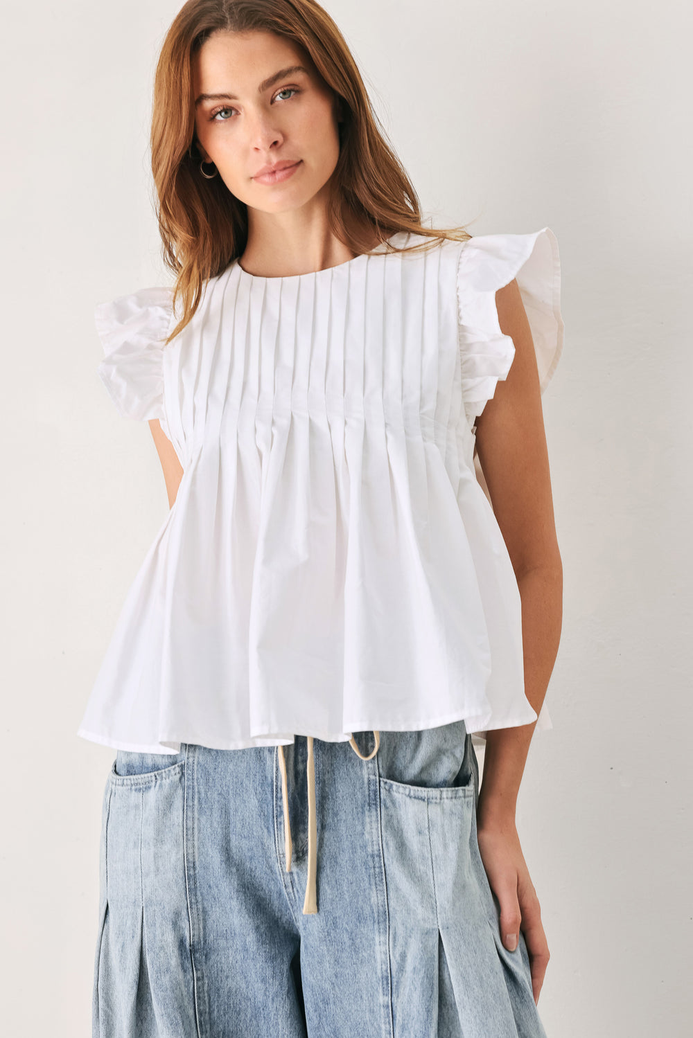 Woman wearing a white blouse with ruffled sleeves | FREEMARKET