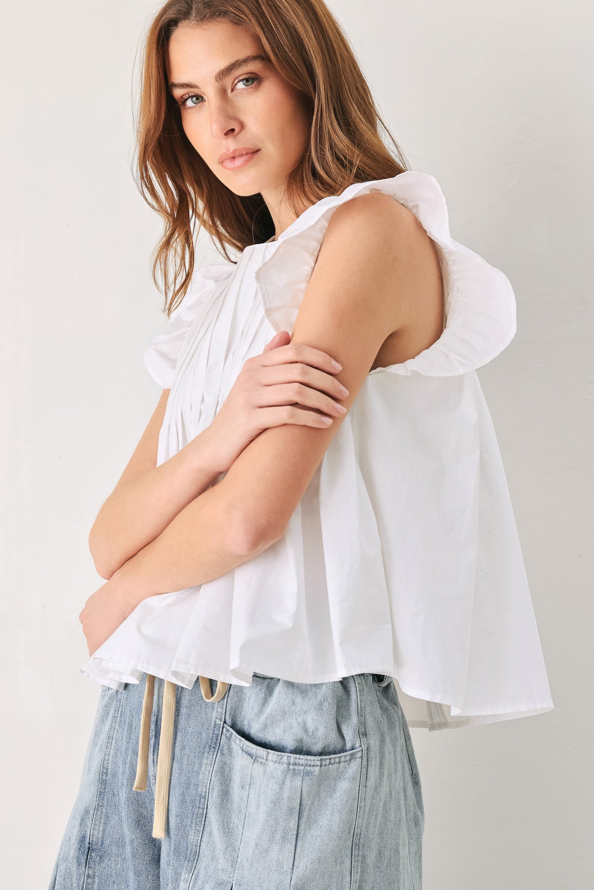 Woman wearing a white blouse with ruffled sleeves | FREEMARKET