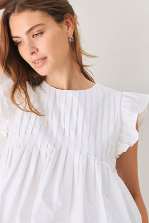 Woman wearing a white blouse with ruffled sleeves | FREEMARKET