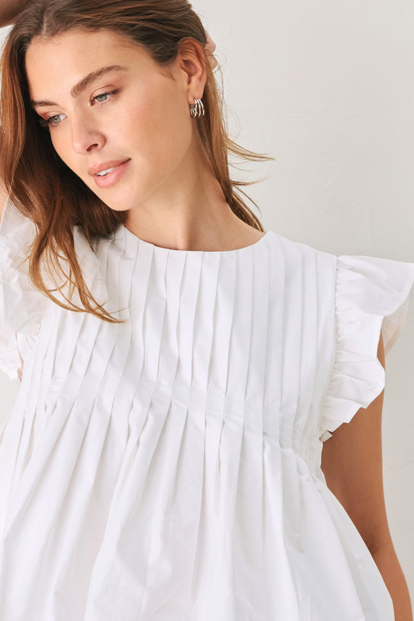 Woman wearing a white blouse with ruffled sleeves | FREEMARKET