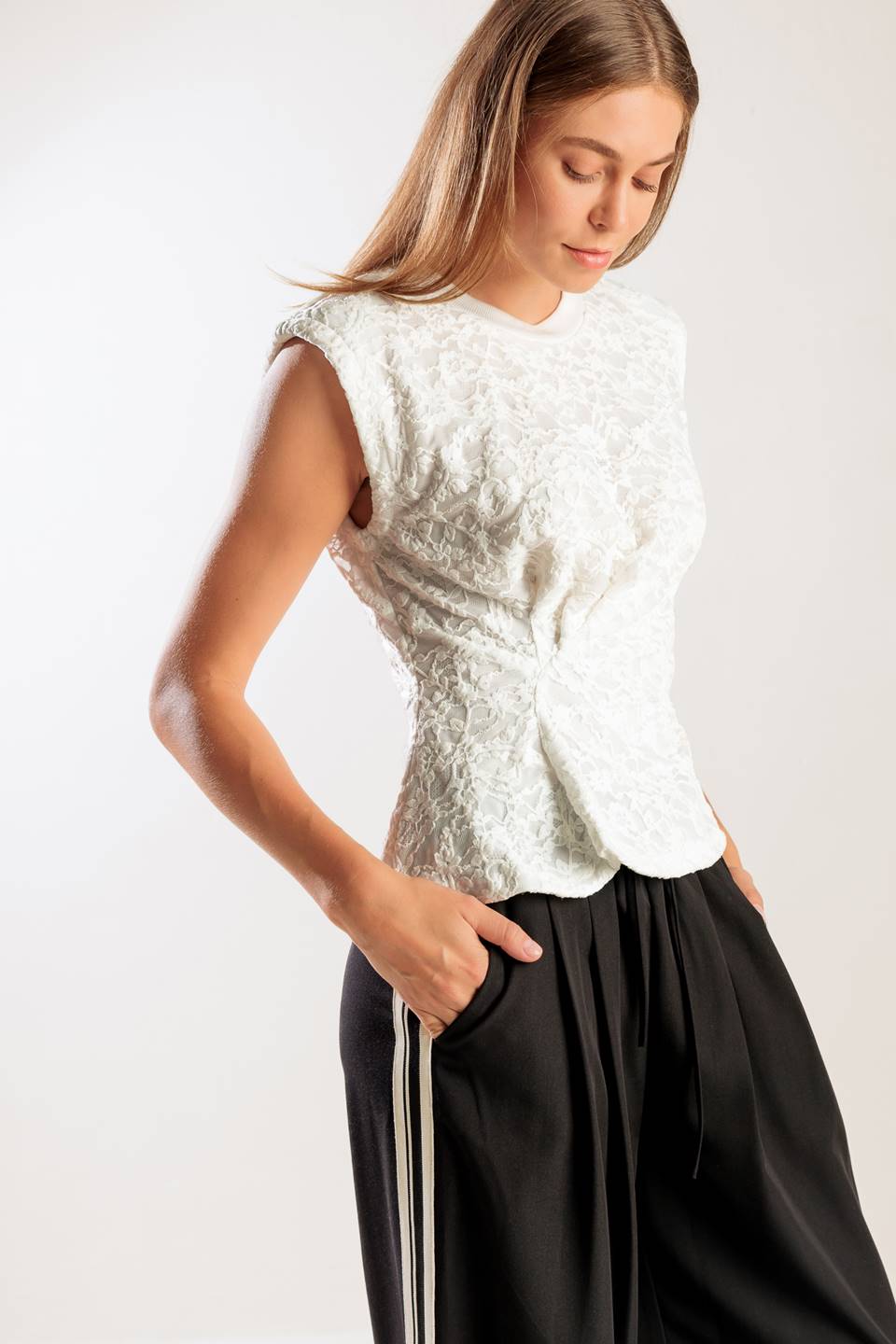 A sleeveless white woven lace top featuring a round neckline and cinched front