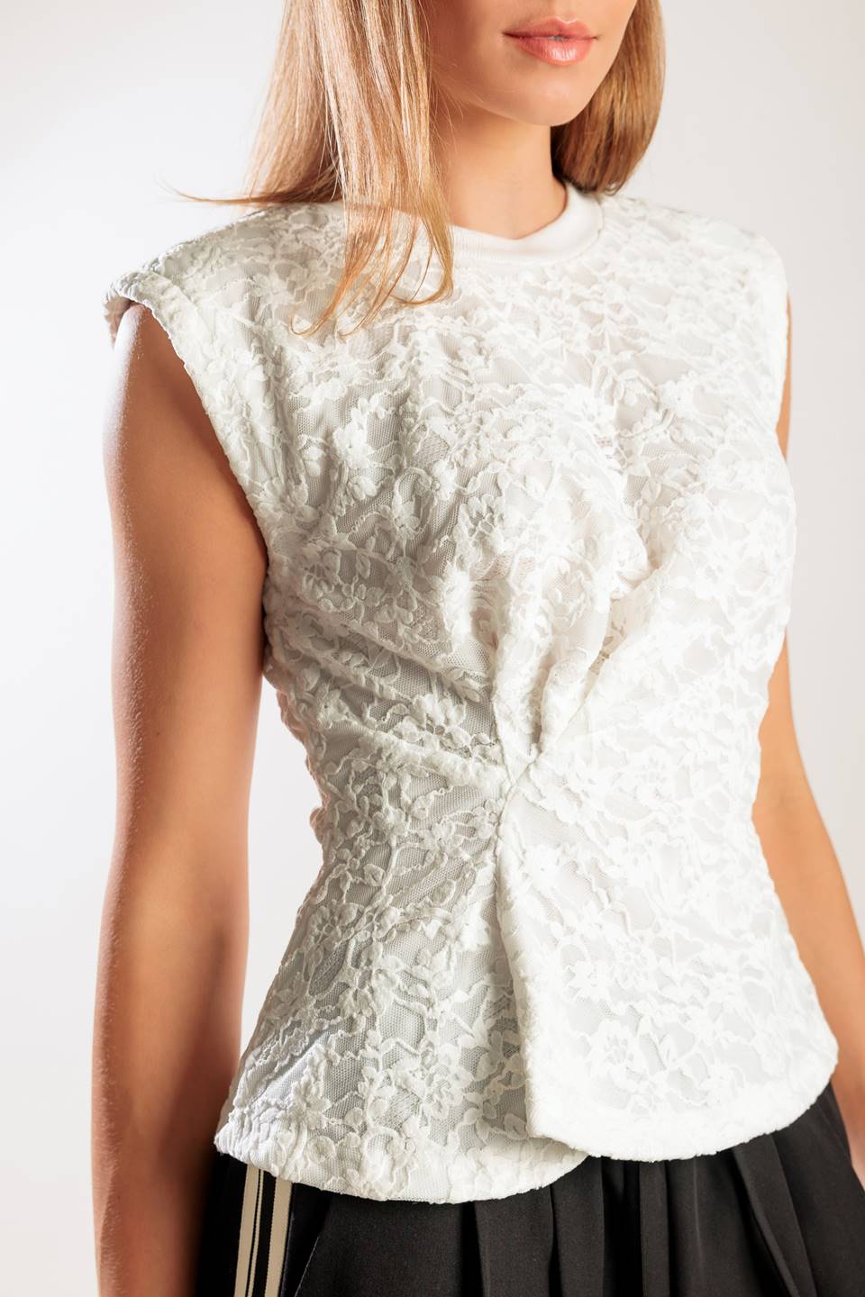 A sleeveless white woven lace top featuring a round neckline and cinched front