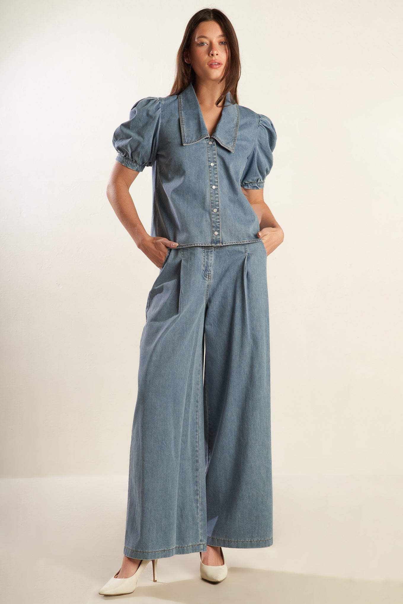 A light denim washed chambray top featuring collar, short puff sleeve with cuff and button down.