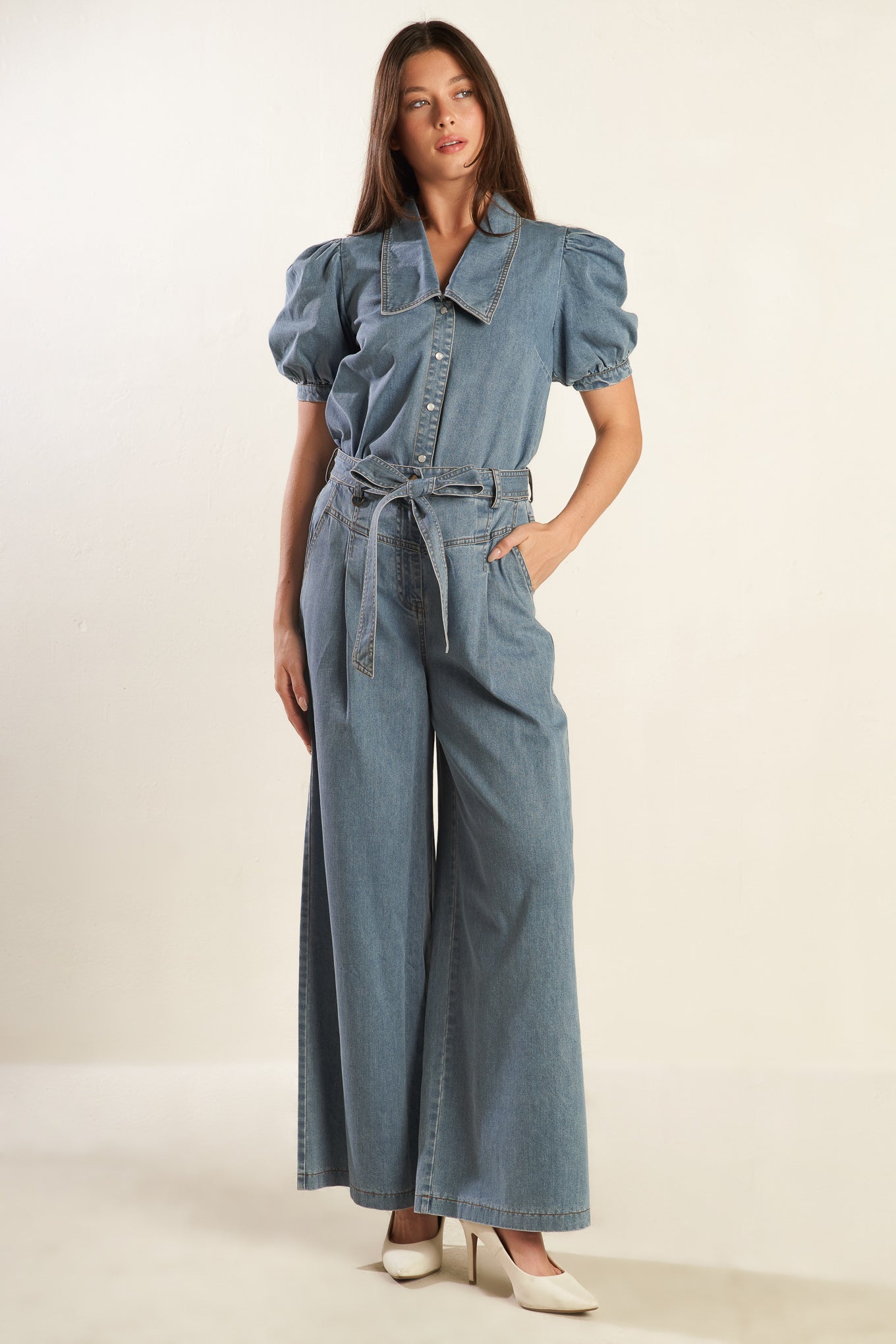 A light denim washed chambray top featuring collar, short puff sleeve with cuff and button down.