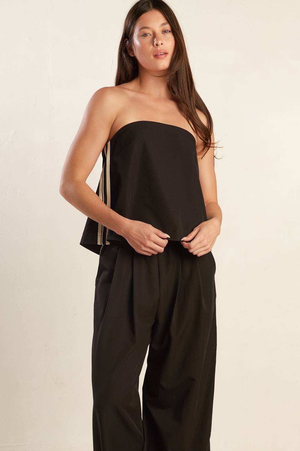 A solid black woven top featuring straight neckline, straps, side striped ribbon and back bow ties.