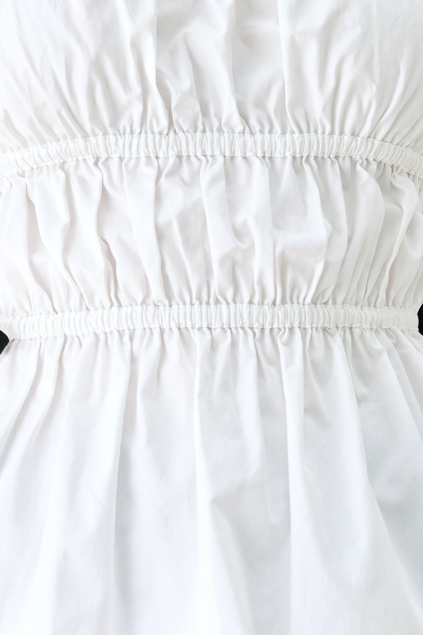 Woman wearing a white strapless top with black side ribbon bow ties | FREEMARKET