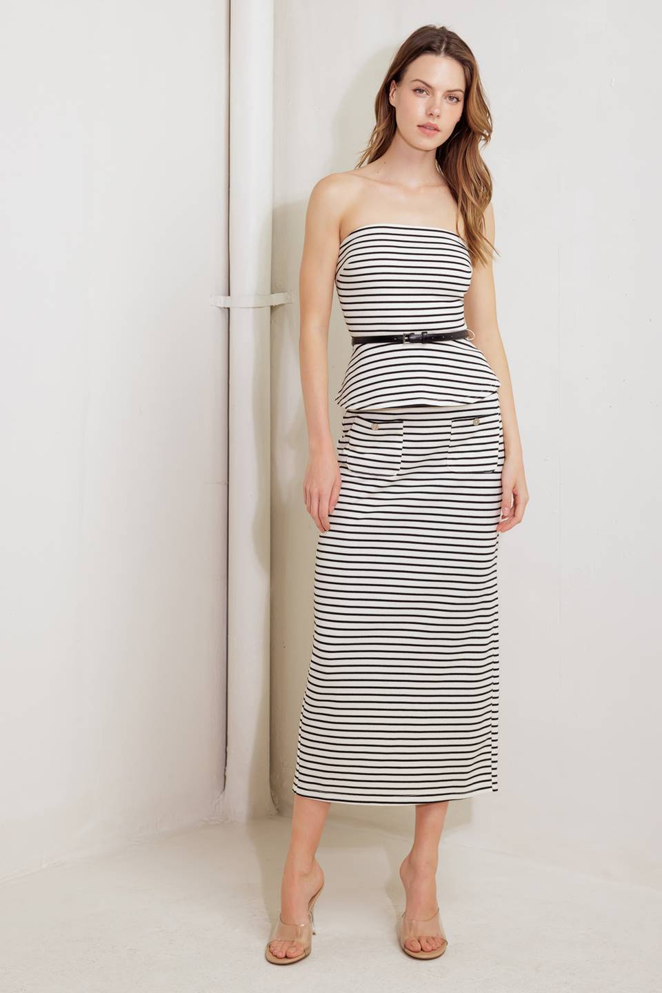 A striped woven tube top with contrasting belt, peplum and back zipper closure.