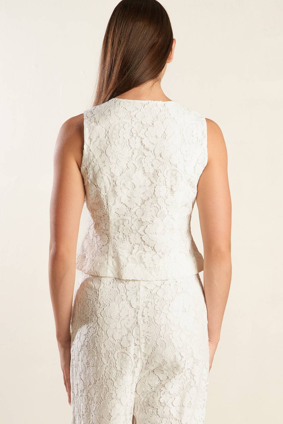 A white sleeveless woven lace vest featuring round neckline and button down.