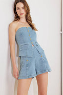 A washed denim top featuring strapless, front button-down detail and back zipper closure.