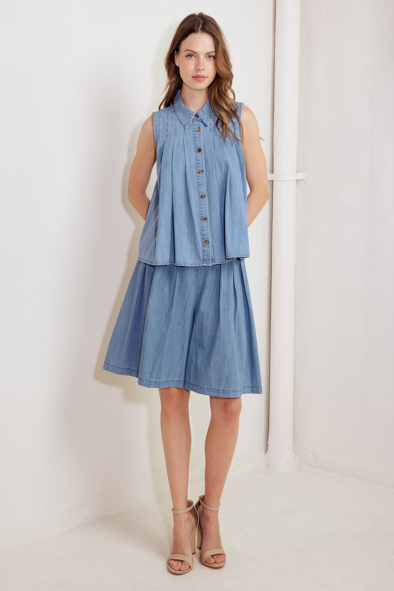 A washed chambray to featuring collar, button down, sleeveless and pleats.