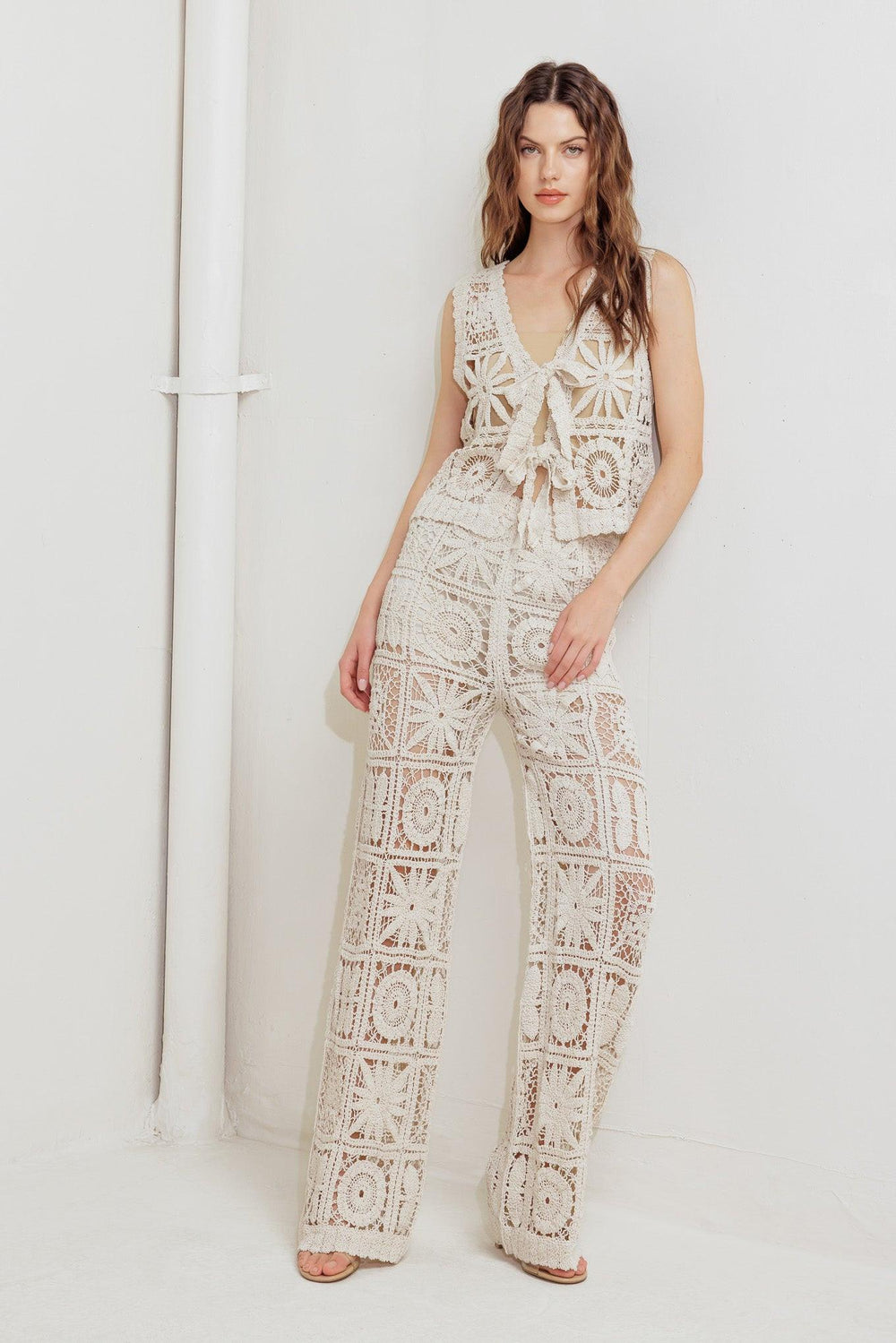 A crochet vest and pant set. Vest featuring front ties and elasticized waist pant