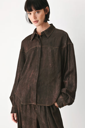 A model wearing a dark brown, washed-out button-up shirt | FREEMARKET