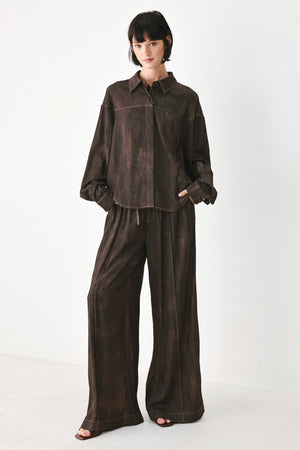A model wearing a dark brown, washed-out button-up shirt | FREEMARKET