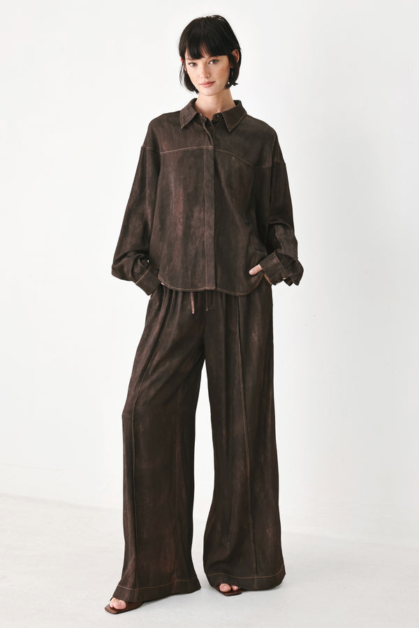 A model wearing a dark brown, washed-out button-up shirt | FREEMARKET