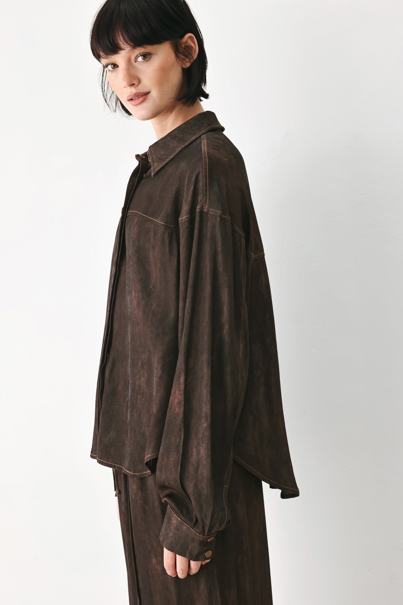 A model wearing a dark brown, washed-out button-up shirt | FREEMARKET