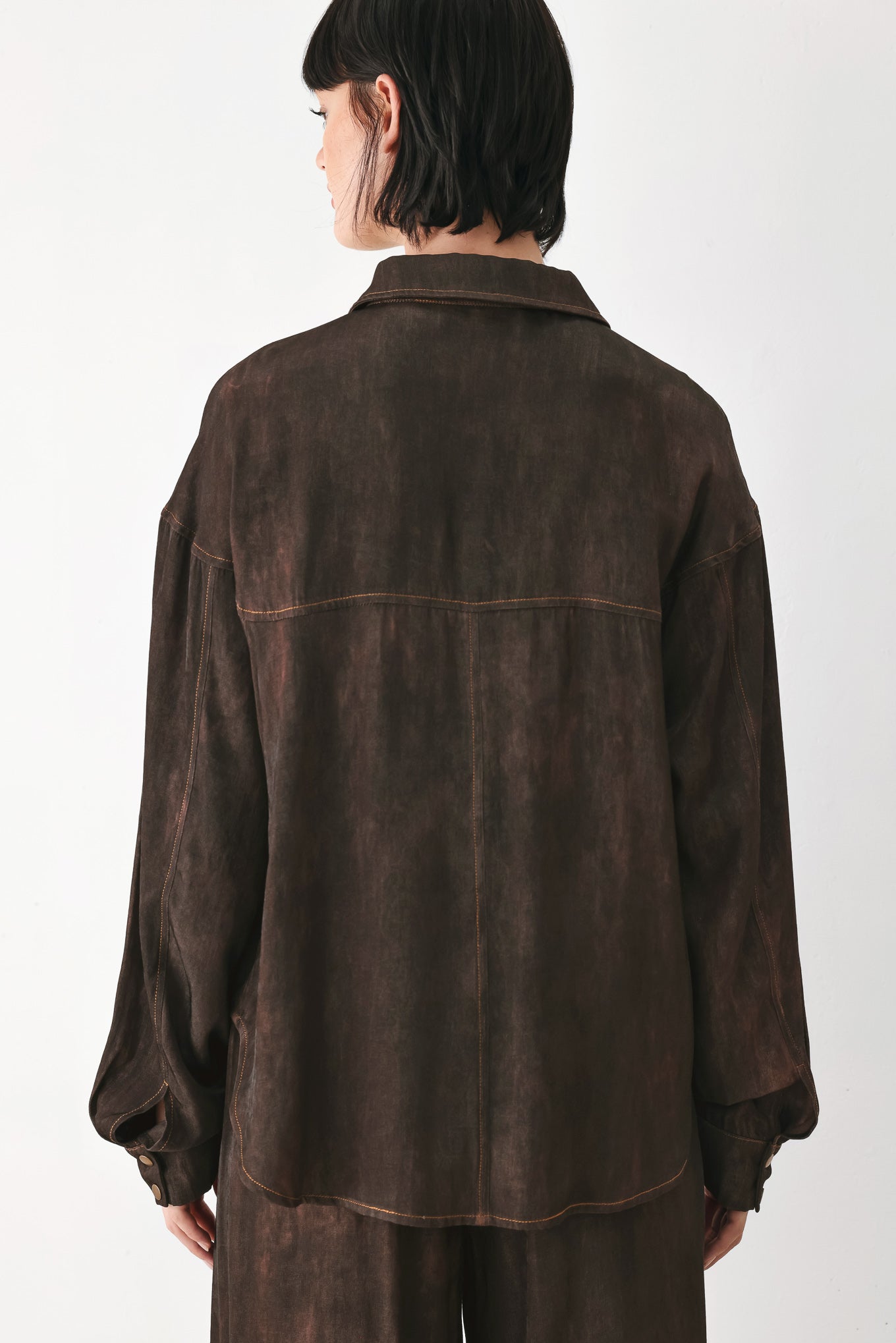 A model wearing a dark brown, washed-out button-up shirt | FREEMARKET