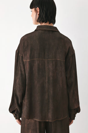 A model wearing a dark brown, washed-out button-up shirt | FREEMARKET