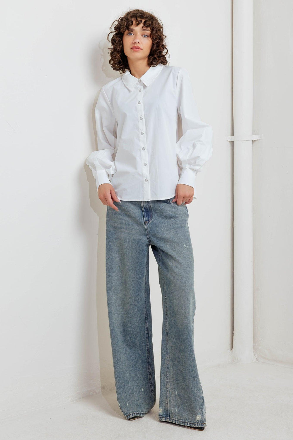 A solid white woven top featuring collar, front snap button down and long sleeve