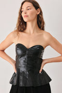 A woman wearing a black strapless faux-leather peplum top with a sweetheart neckline and structured bust | FREEMARKET