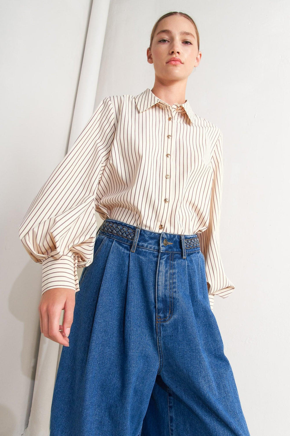 A striped woven top featuring collar, long sleeve and front button down