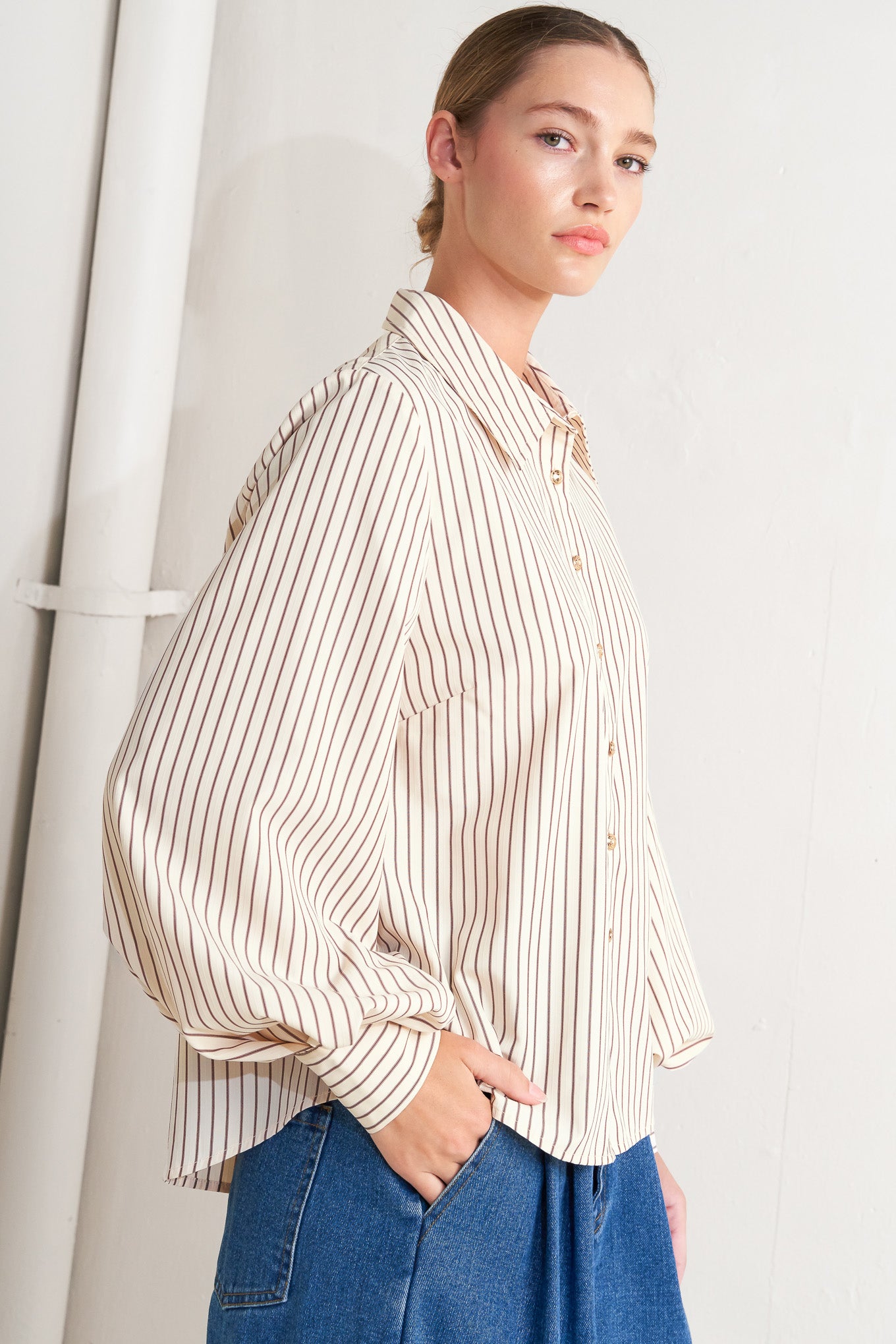 A striped woven top featuring collar, long sleeve and front button down