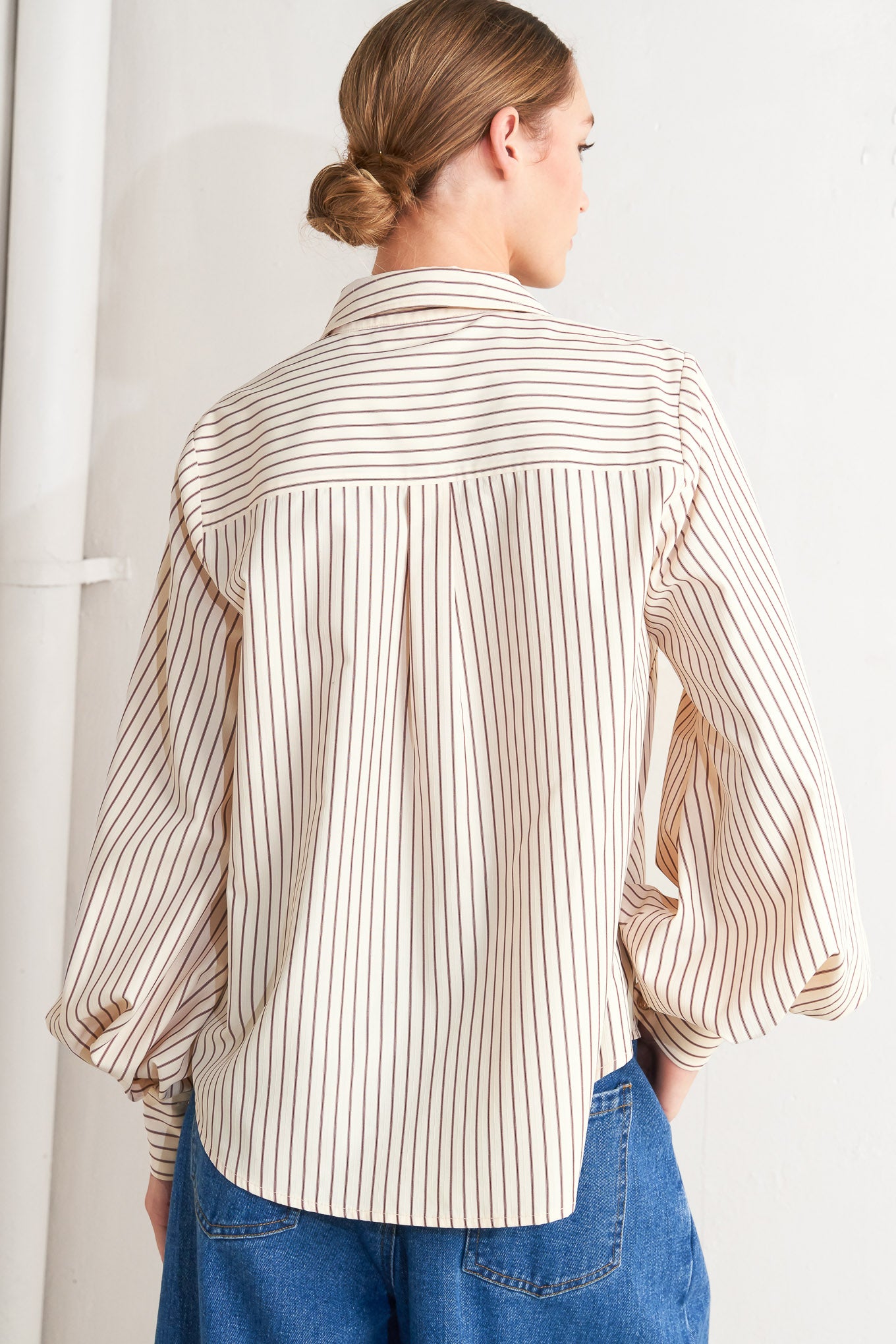 A striped woven top featuring collar, long sleeve and front button down