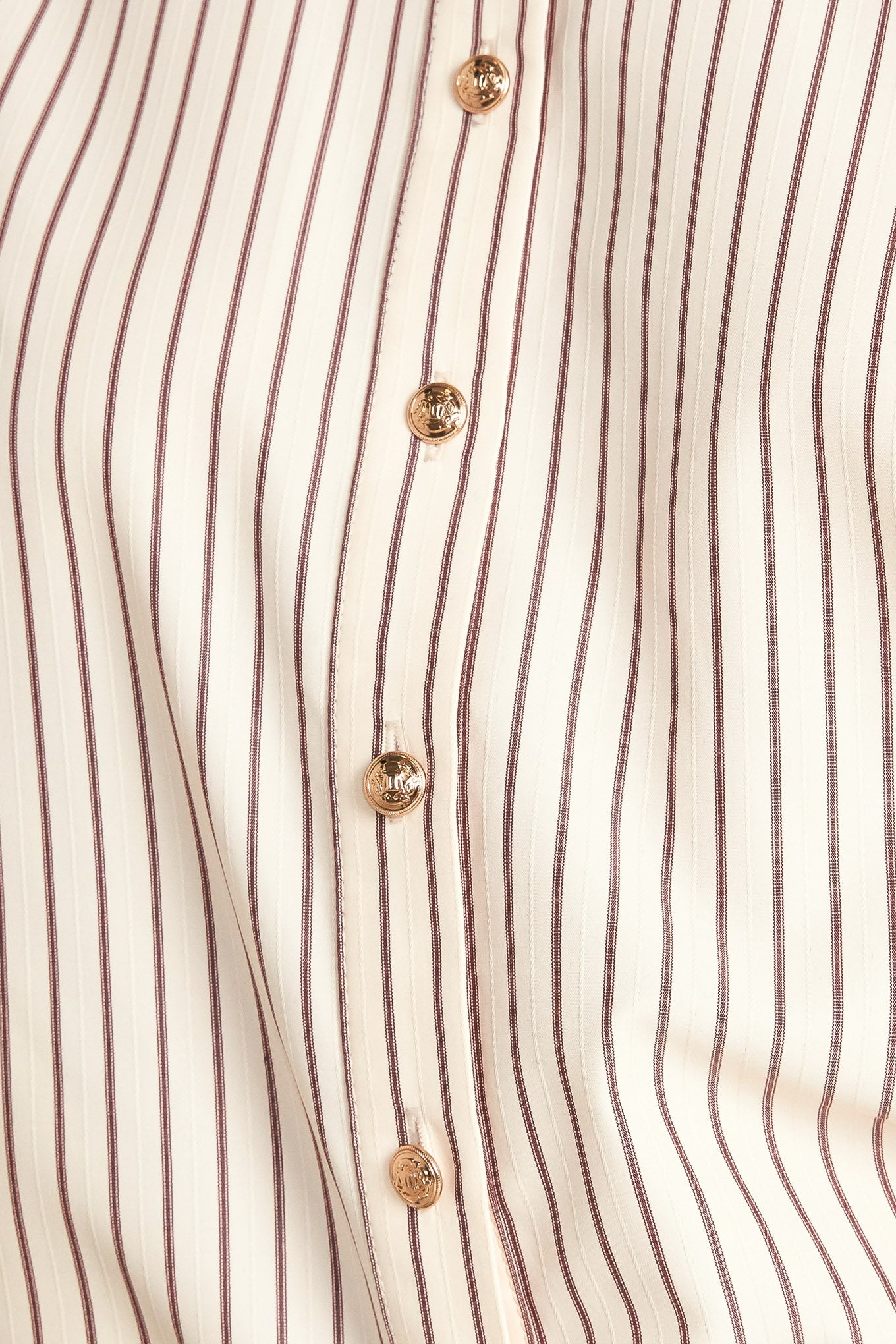 A striped woven top featuring collar, long sleeve and front button down