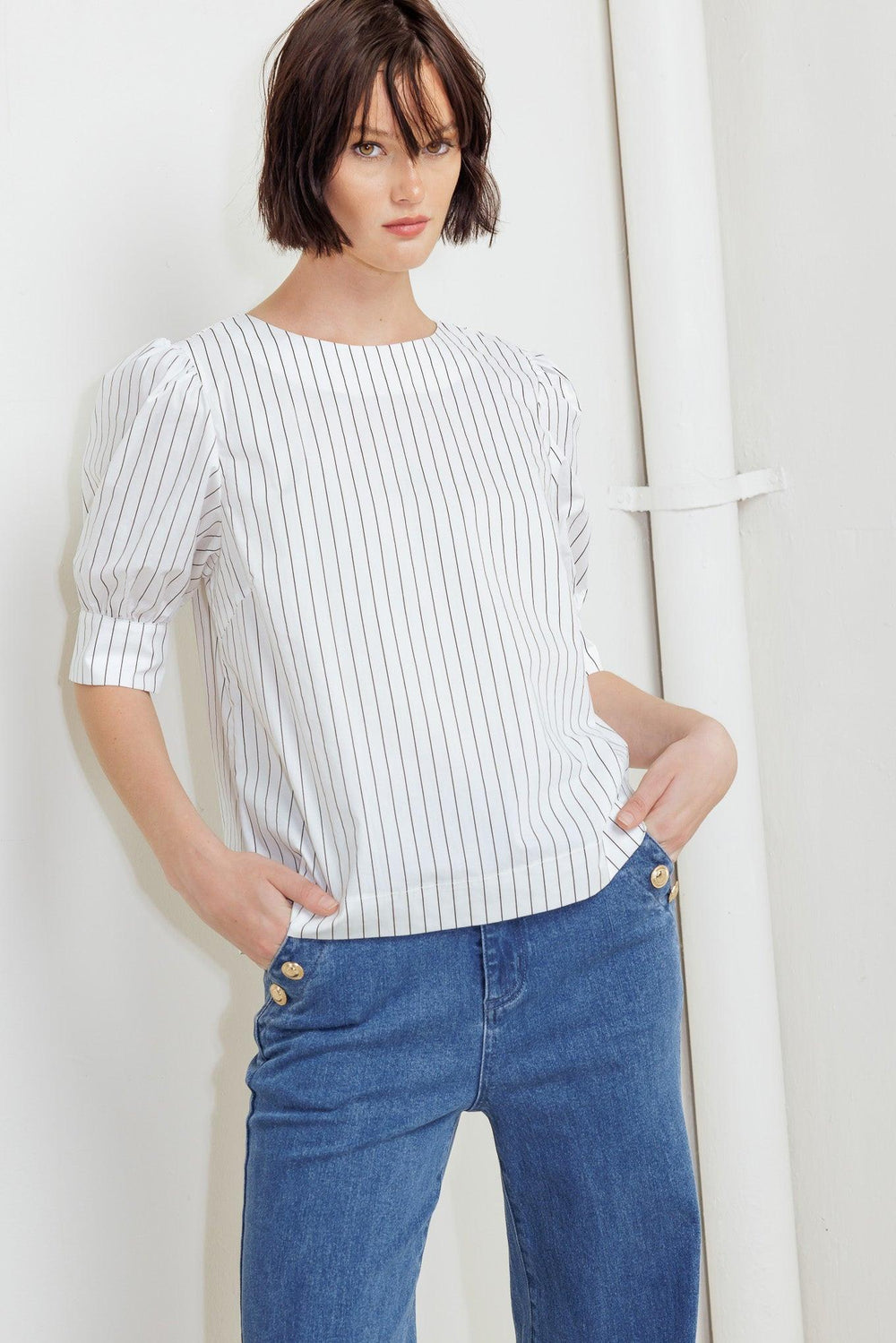 A striped woven top featuring round neckline, short puff sleeve with cuff and back button down closure