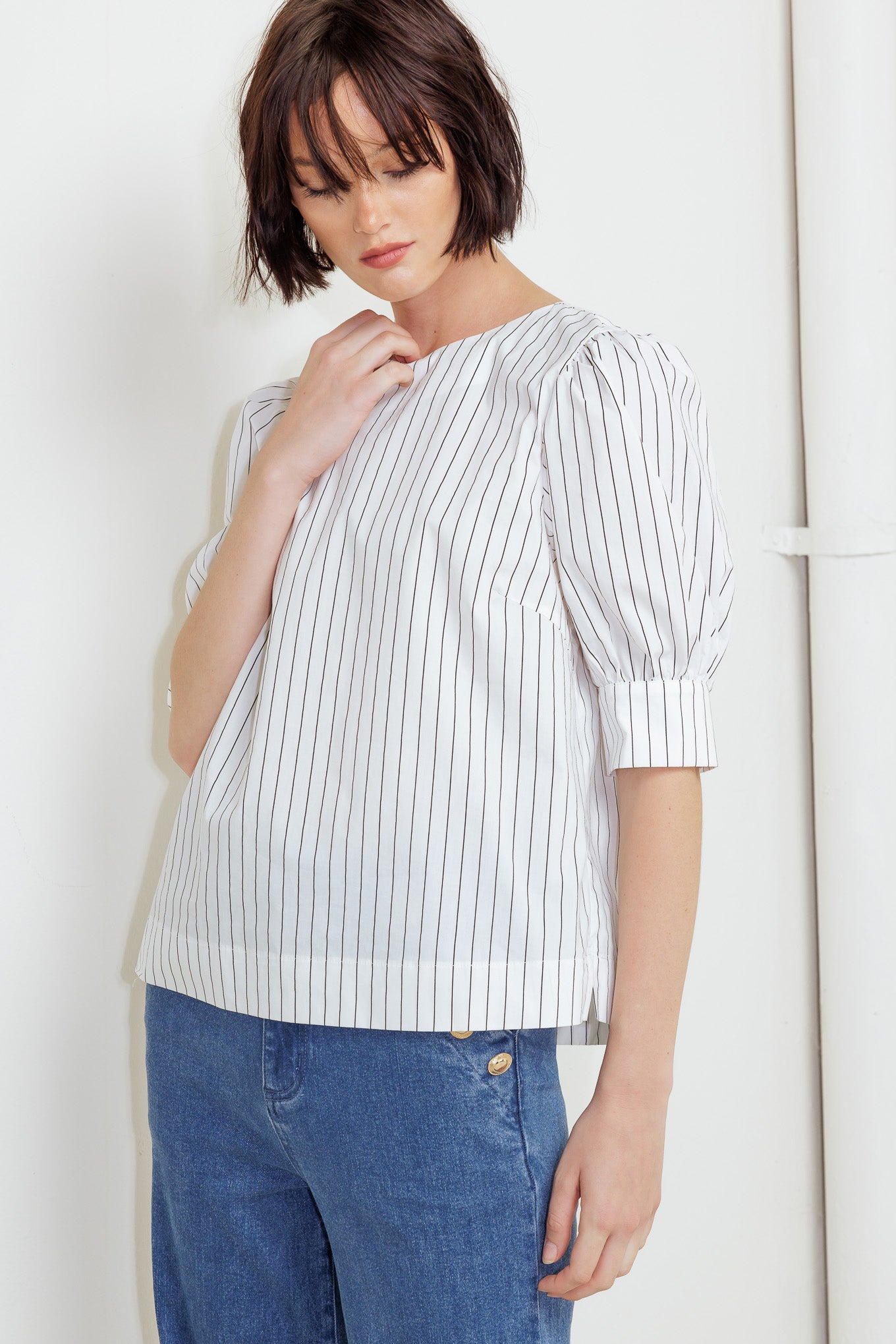 A striped woven top featuring round neckline, short puff sleeve with cuff and back button down closure