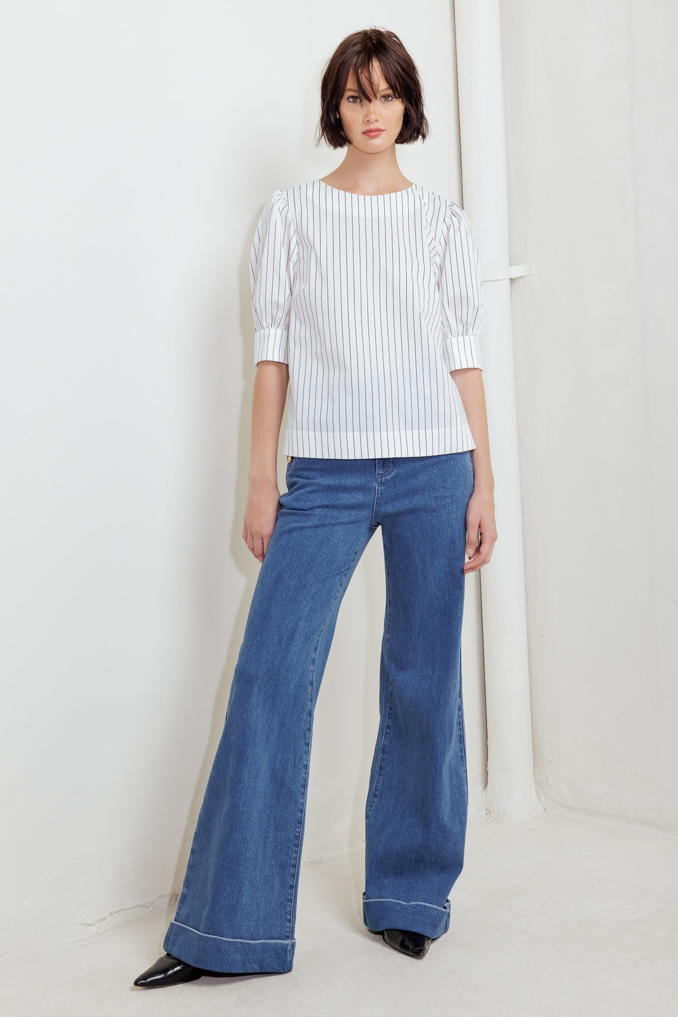 A striped woven top featuring round neckline, short puff sleeve with cuff and back button down closure