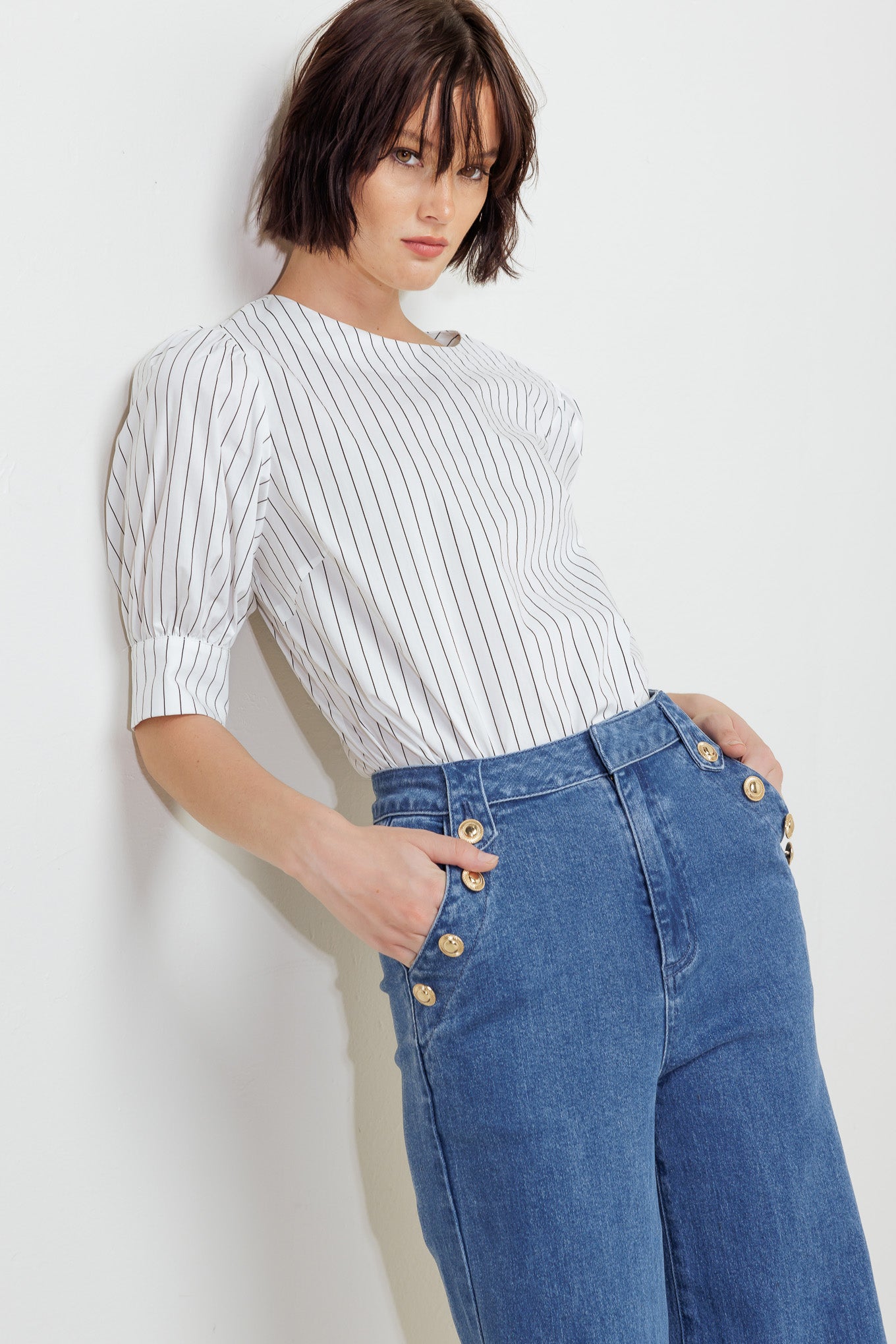A striped woven top featuring round neckline, short puff sleeve with cuff and back button down closure